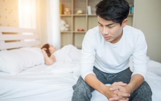 Man sitting on bed with erectile dysfunction